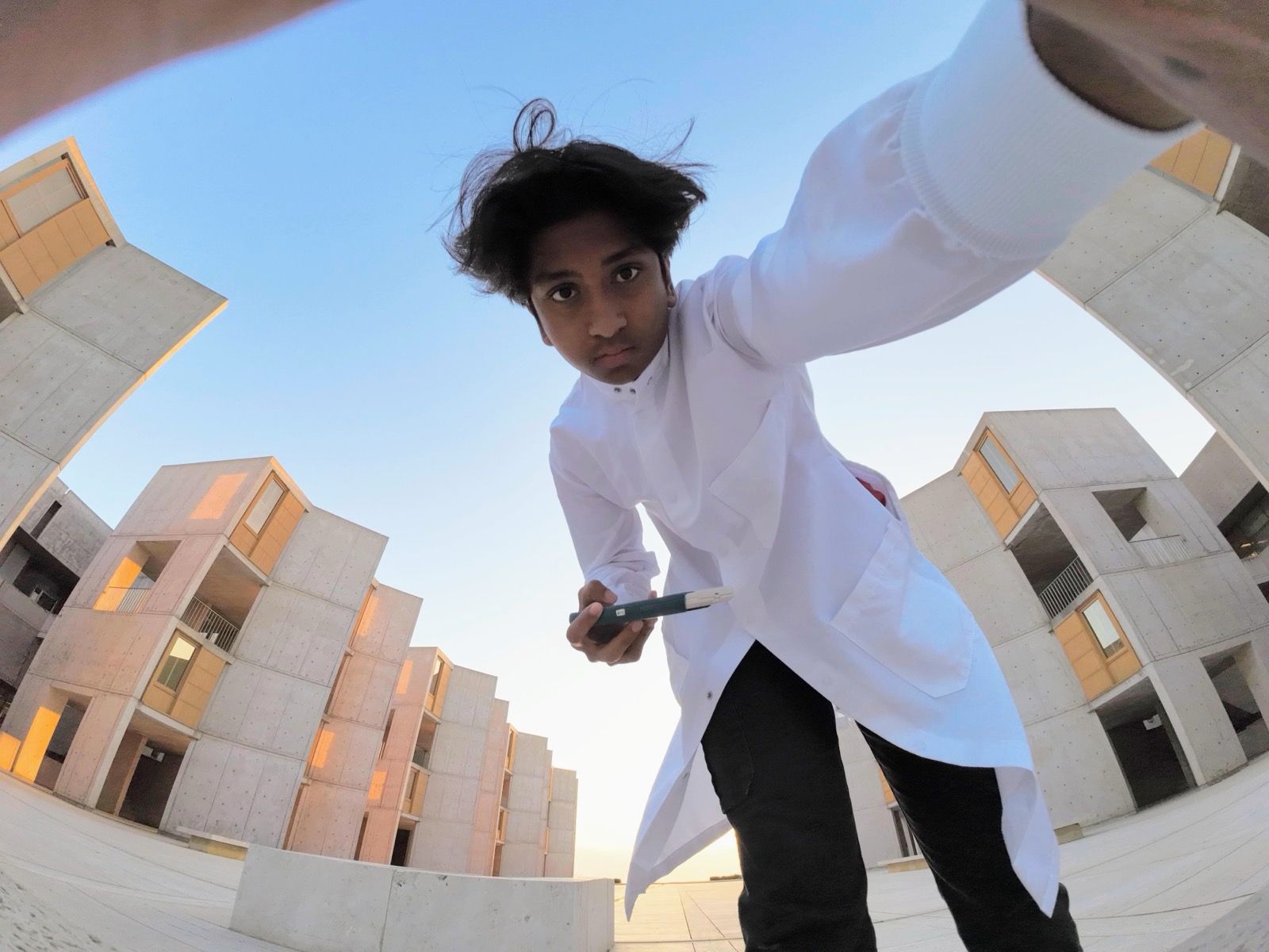 Sid in a lab coat at the Salk Institute courtyard